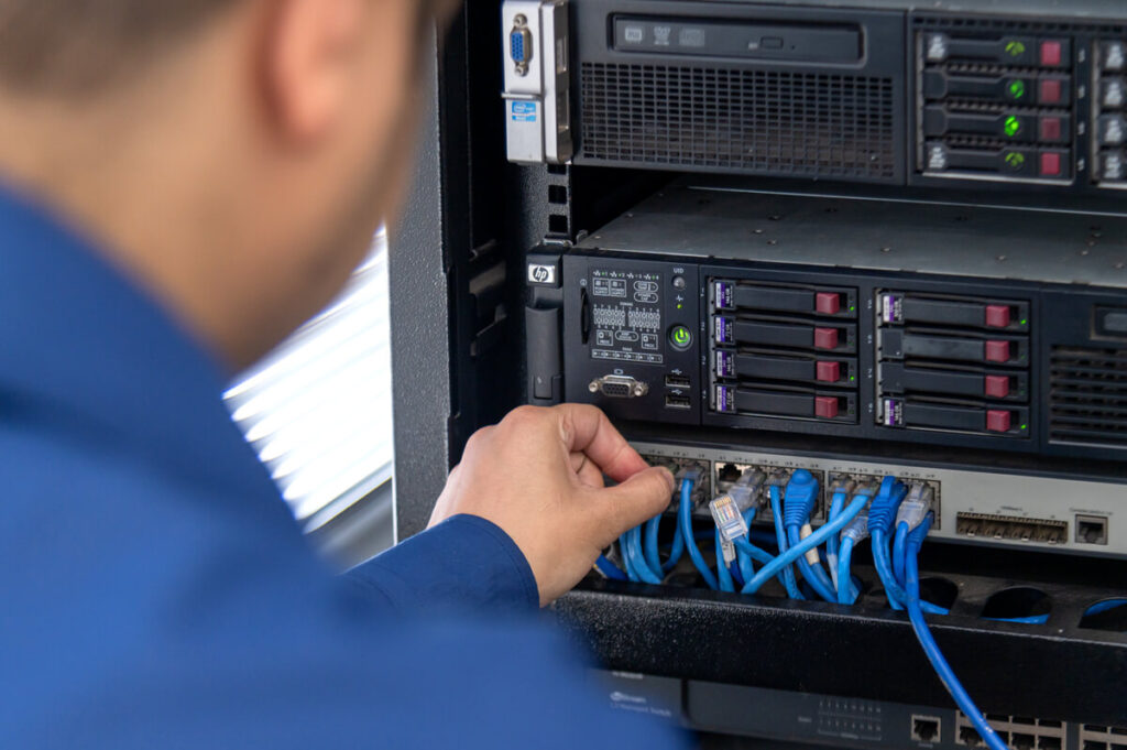 homem de costas verificando cabos de conexão em hack de hds
