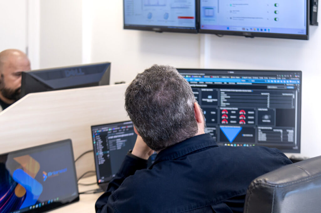equipe de tecnologia analisando dados em vários computadores
